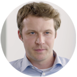 Person in professioneller Umgebung, neutraler Hintergrund.